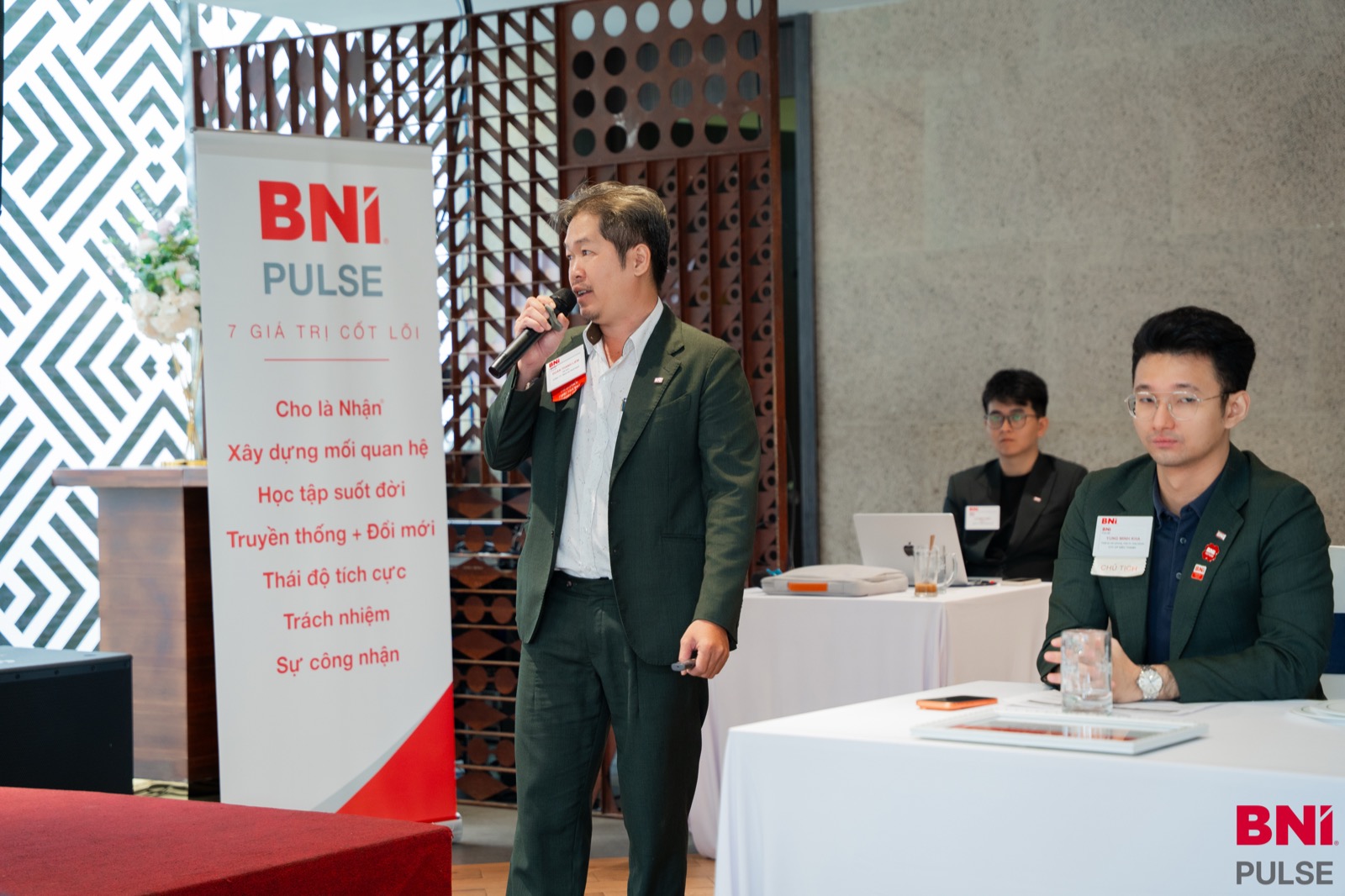 Mr. Đoàn Thanh Liêm chia sẻ bên cạnh banner 7 giá trị cốt lõi của BNI Pulse Chapter